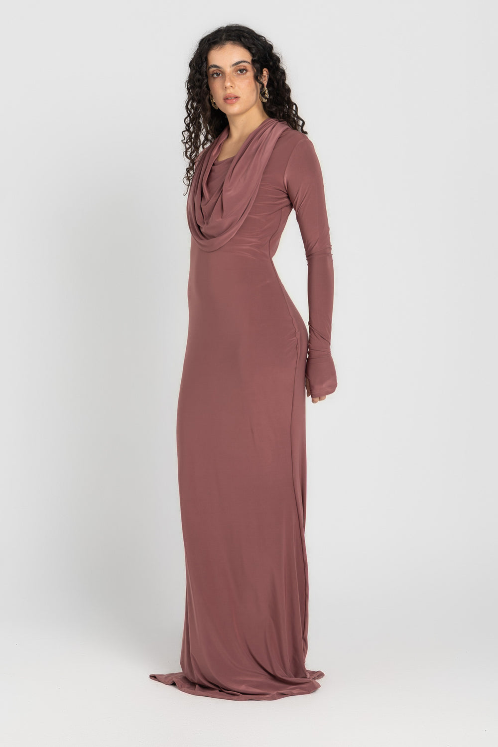 Woman wearing a long, cashmere dress with a hood on a white background