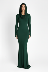 Woman wearing a long green dress with a hood on a white background