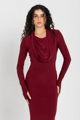 Woman wearing a burgundy dress with a cowl neckline on a white background