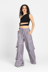 Woman wearing a black crop top and gray cargo pants on a white background