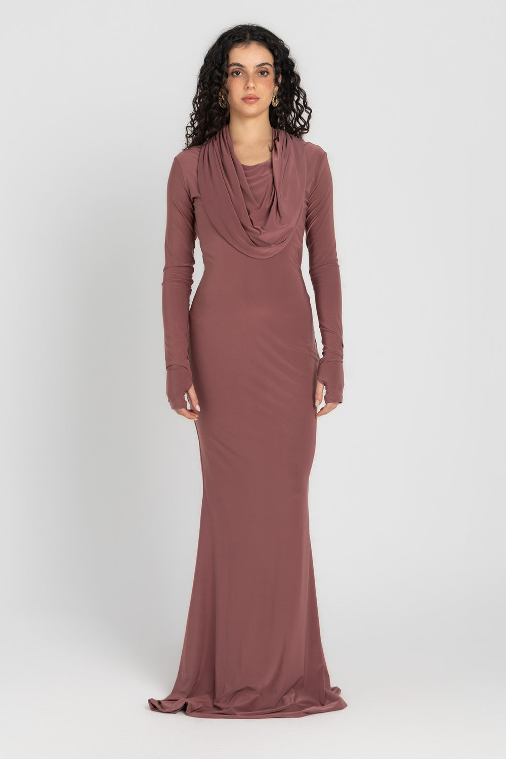 Woman wearing a long, cashmere dress with a hood on a white background