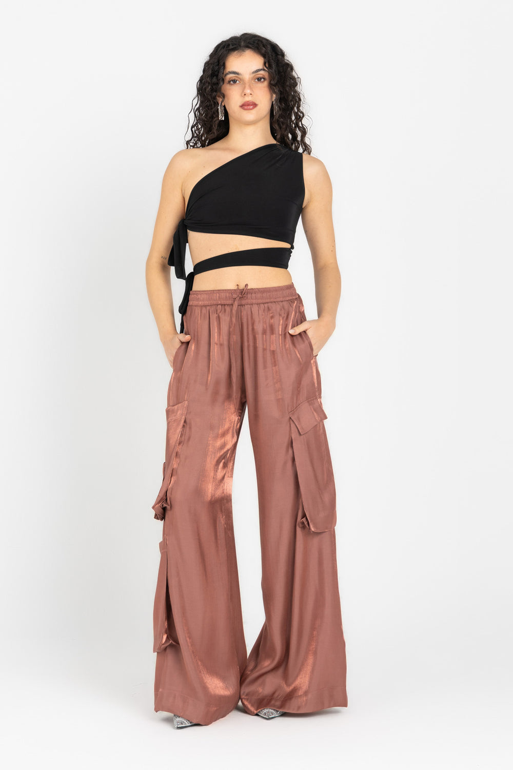 Woman wearing a black top and brown wide-leg pants on a white background