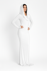 Woman wearing a long white dress with a hood on a white background